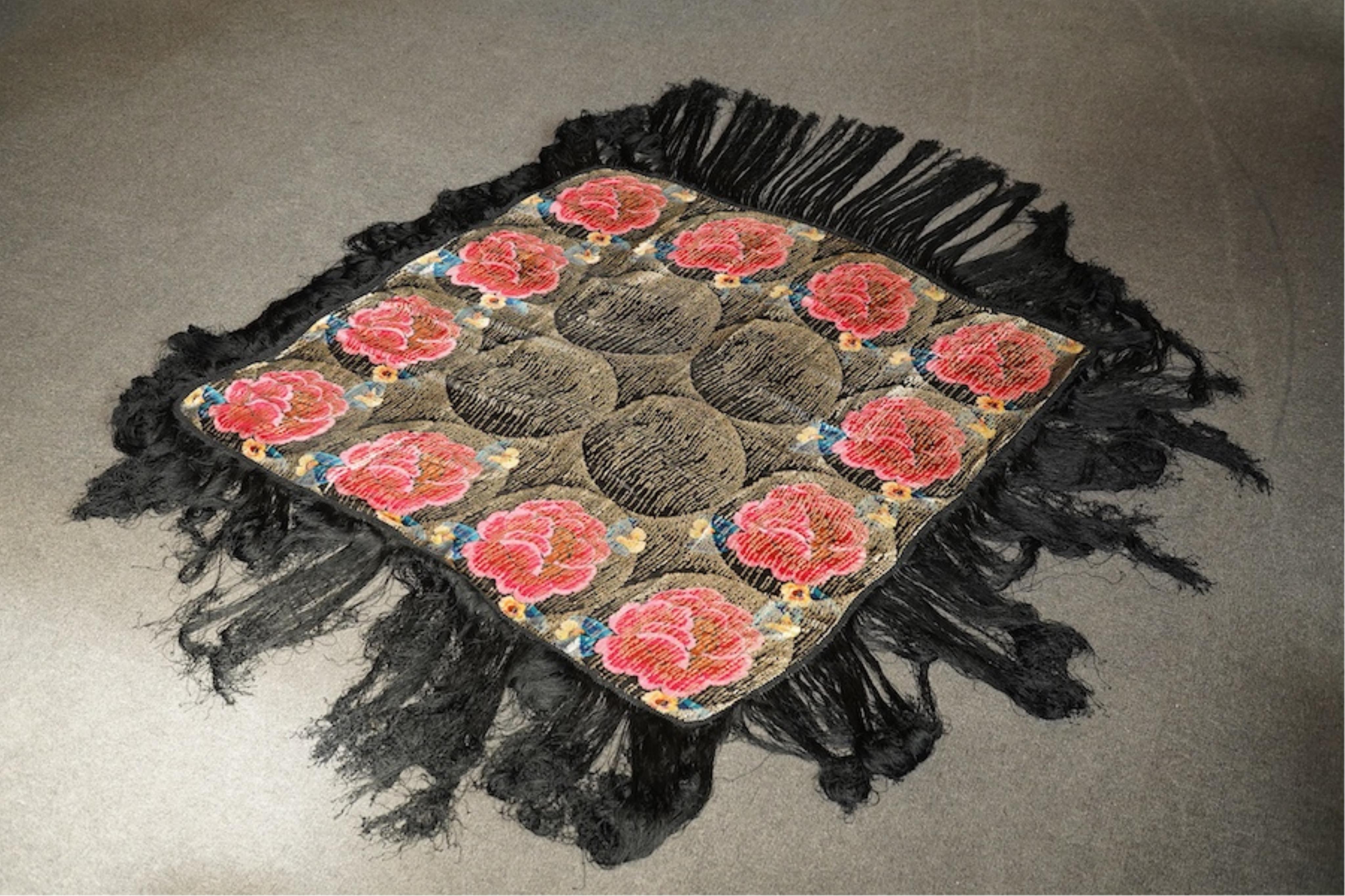 A 1930's ‘jazz age’ black and coloured silk lame evening shawl. Woven with giant pink and red roses and silver thread stripes, edged with long silk fringing. 118cm x 123cm. Condition - colours and silk strong. Fringing g